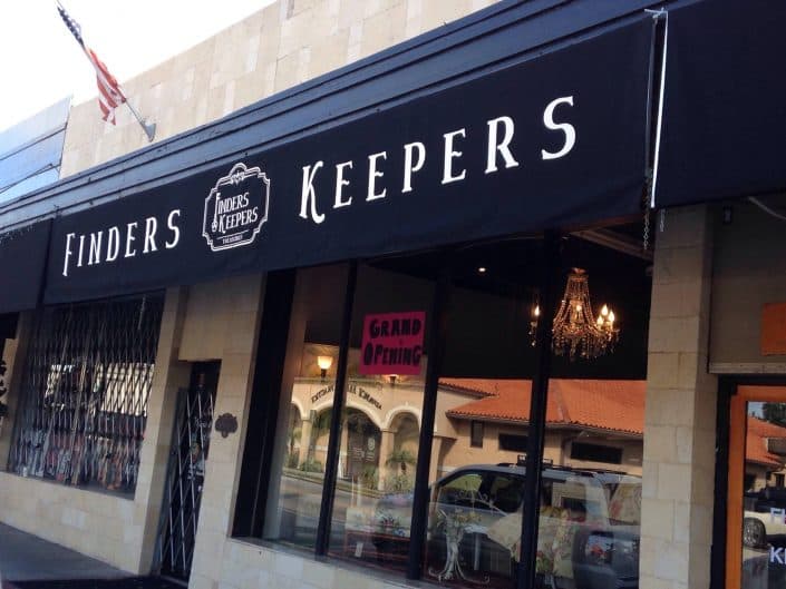 Finders Keepers store front with banner announcing grand opening and stylish decor.