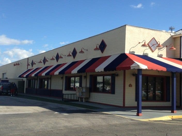 Colorful restaurant exterior with red, white, and blue awning and decorative accents.