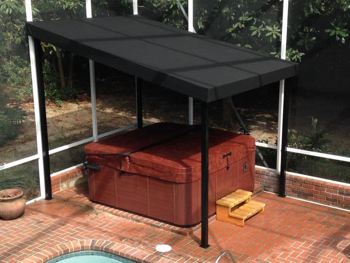 Hot tub with protective canopy in a backyard setting, surrounded by greenery and brick patio.