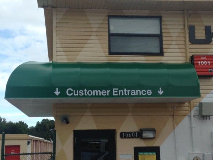 Green awning with "Customer Entrance" signage on a building exterior.